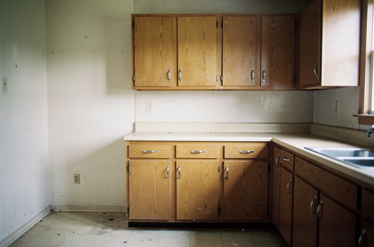 Dated kitchen shot square on and evenly lit the way a property listing photograph is taken