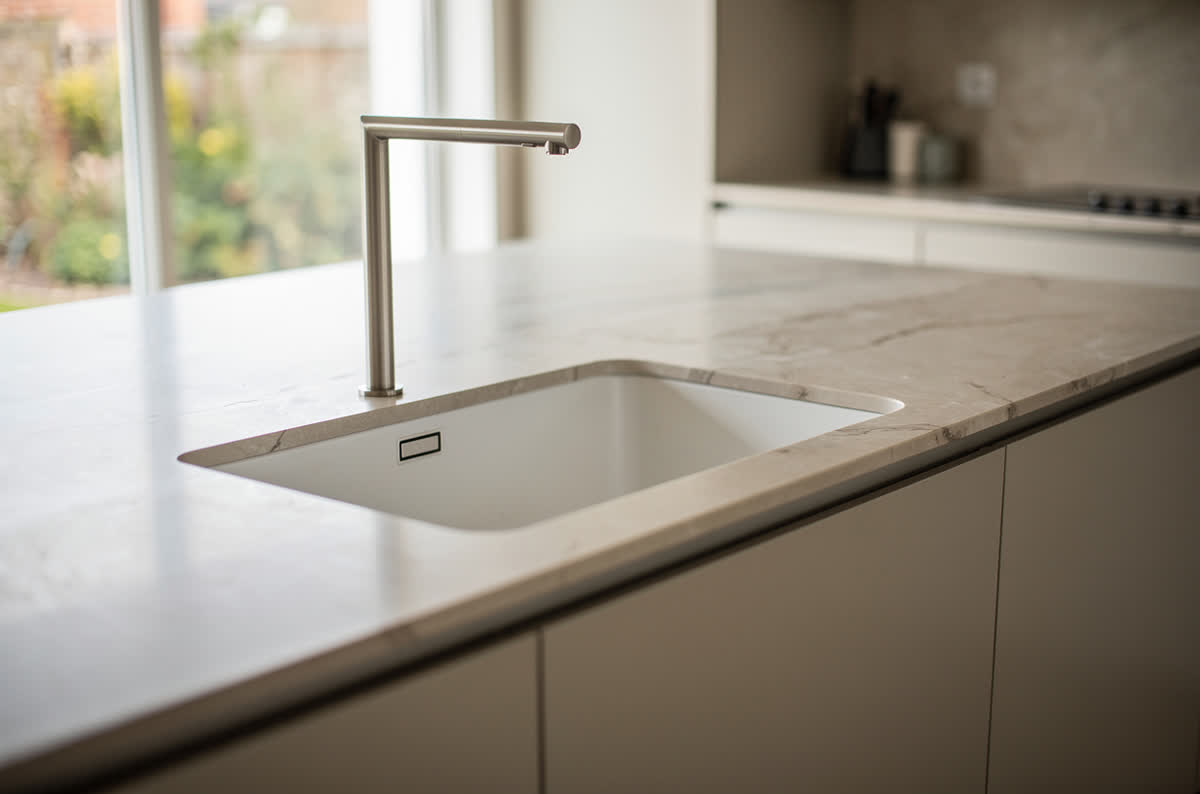 Kitchen island with an integrated undermount prep sink and a slim tall faucet