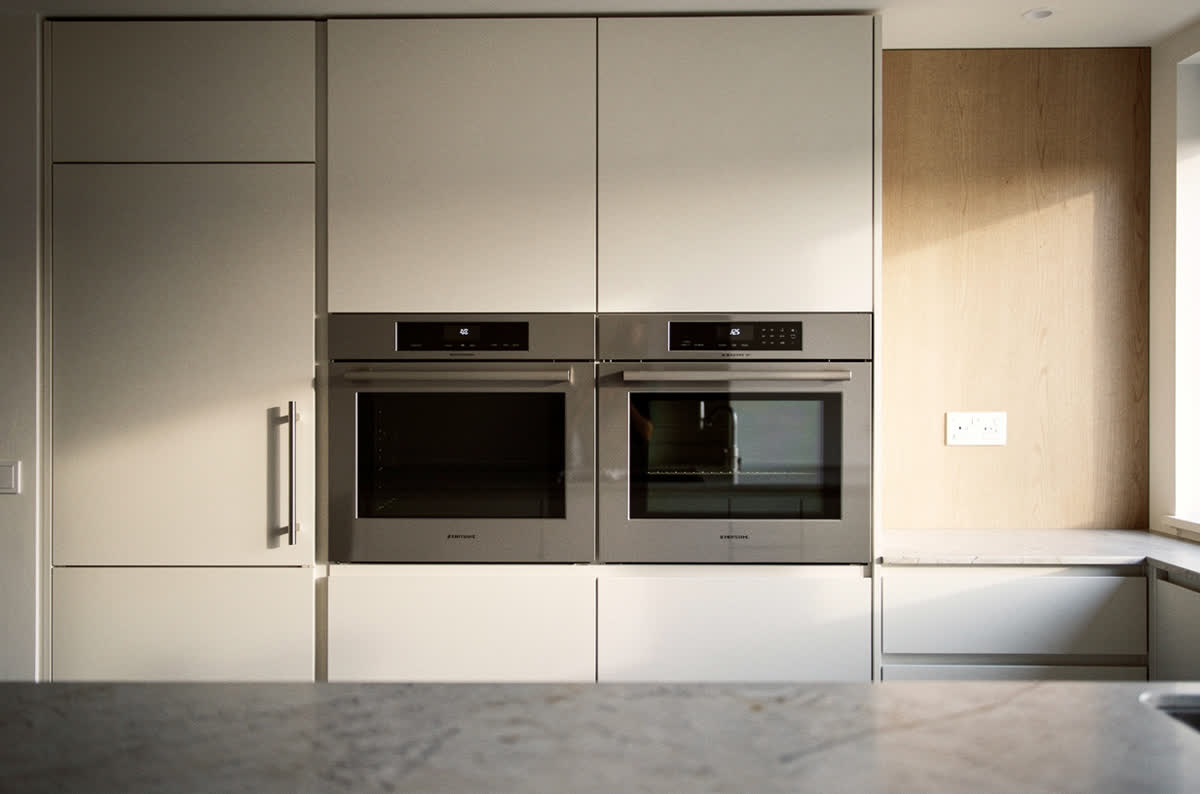 Panel-ready appliances blending into the cabinetry as one unified wall of fronts