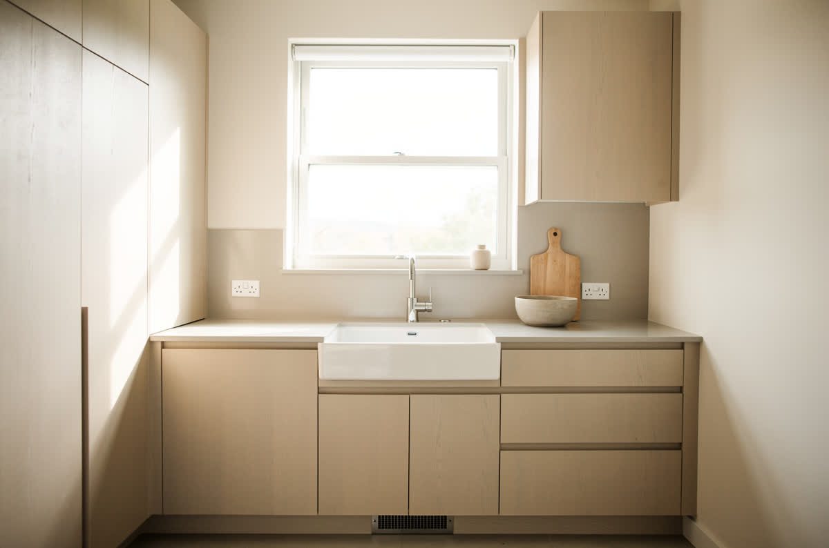 Small kitchen filled with daylight from a large window above the sink