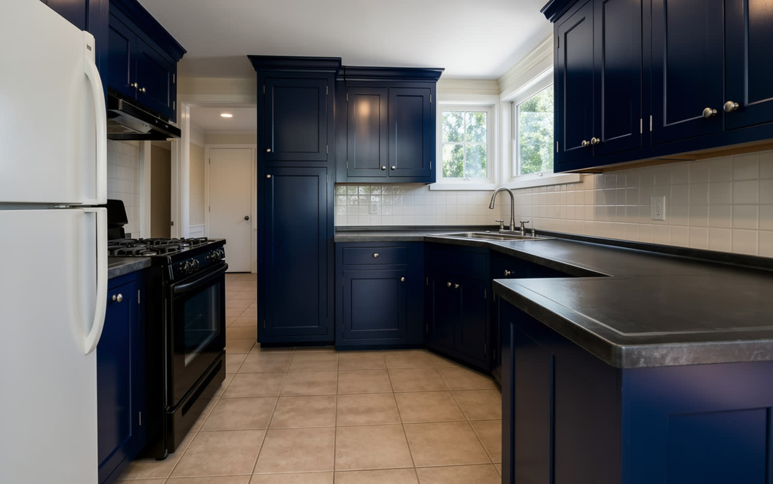The same kitchen with every door repainted deep navy