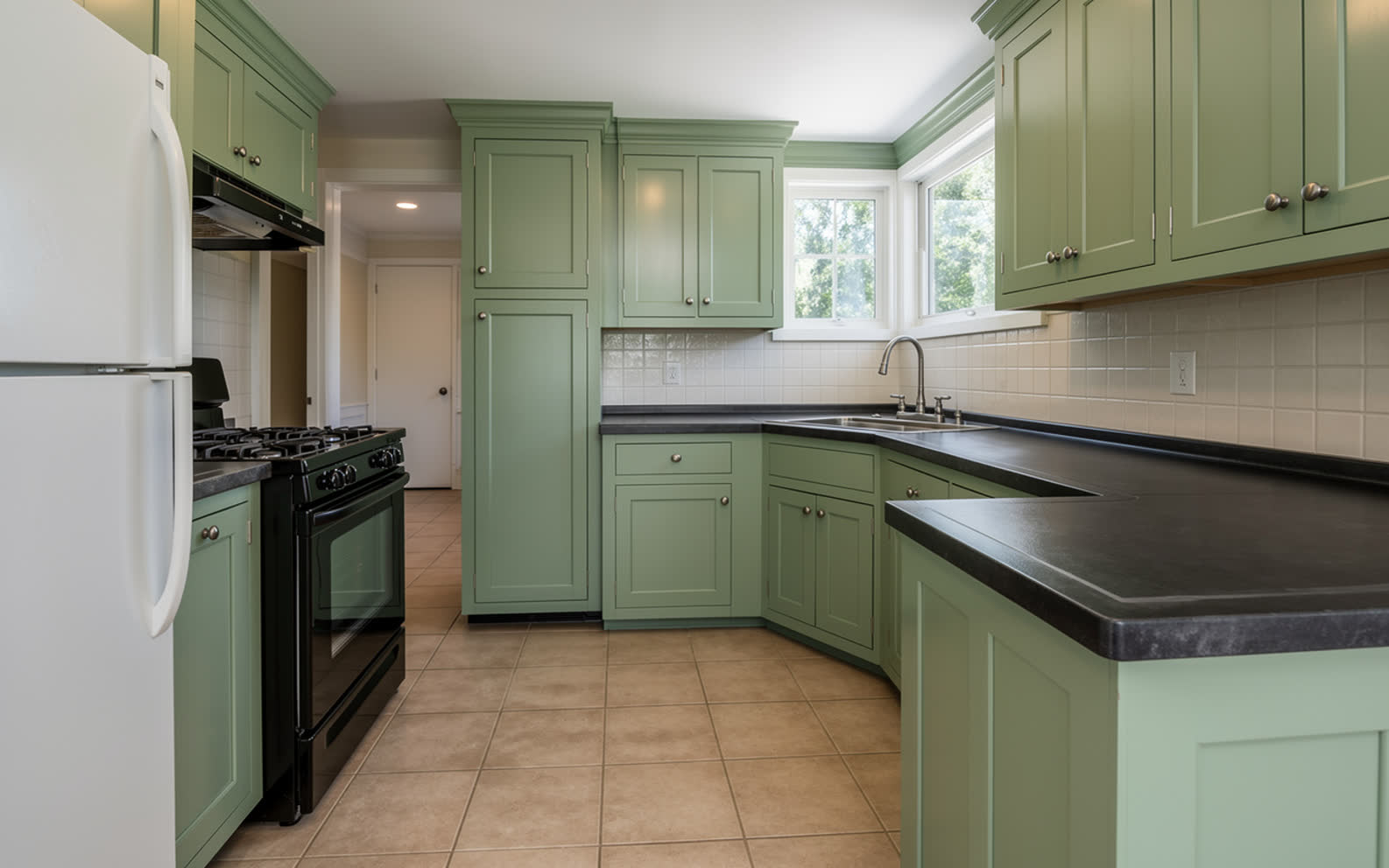 The same kitchen with every door repainted soft sage green